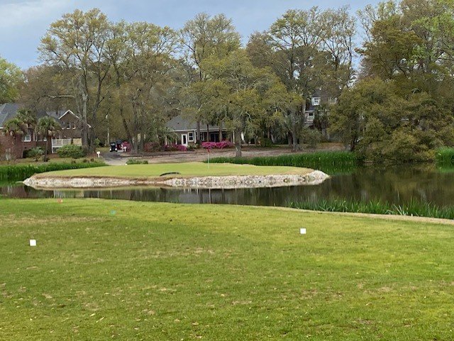 Island green par 3 with azaleas and Spanish moss at Oyster Bay Golf Links Sunset Beach NC
