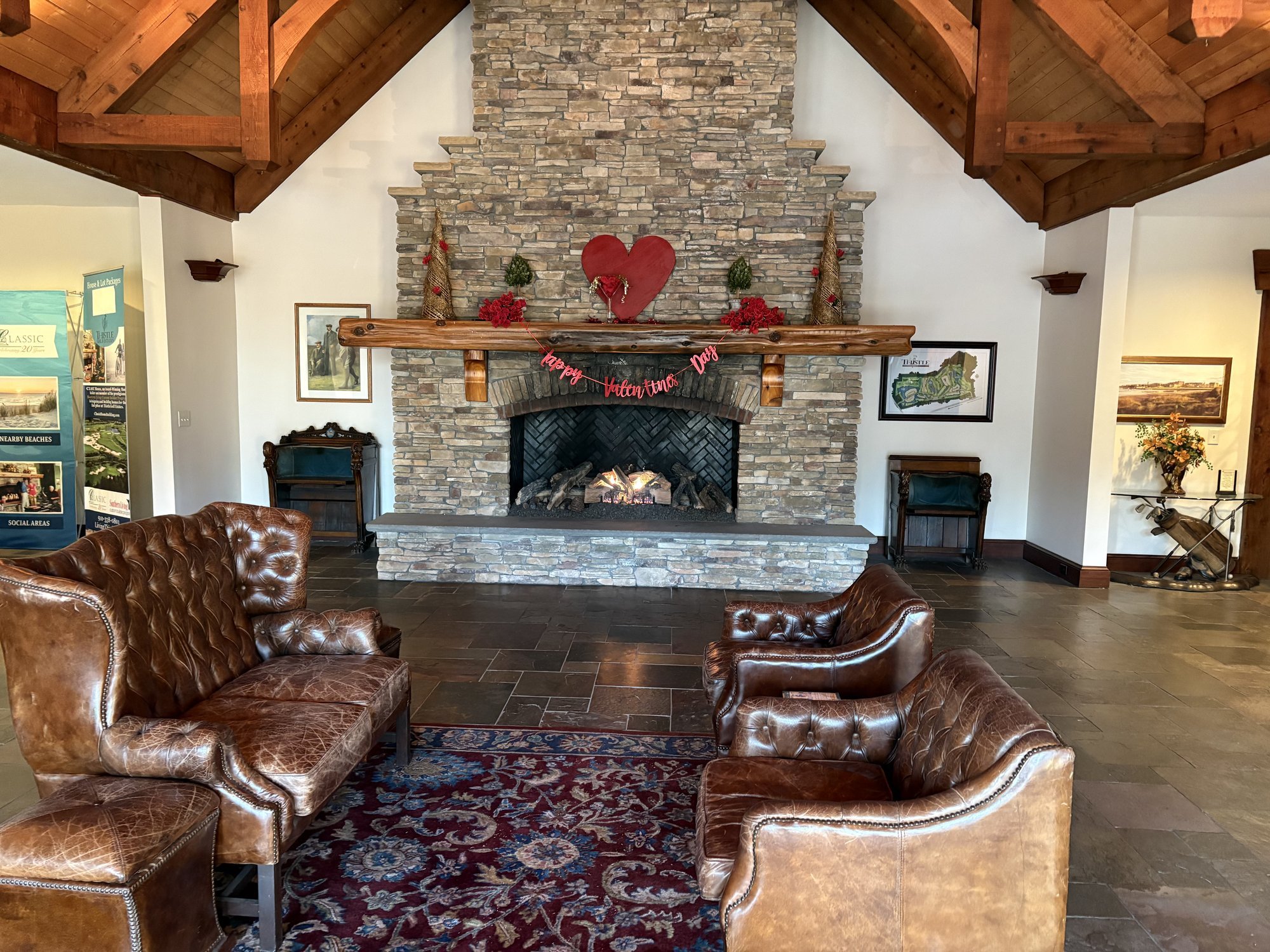 Stone fireplace and leather chairs inside Thistle Golf Club clubhouse Sunset Beach NC