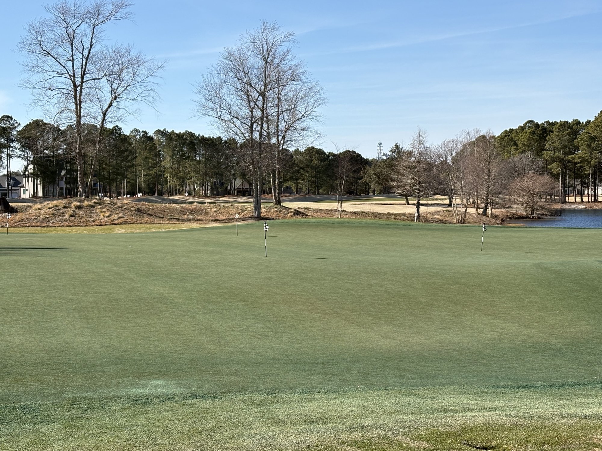 Practice putting green at Thistle Golf Club with water and course views in Sunset Beach NC