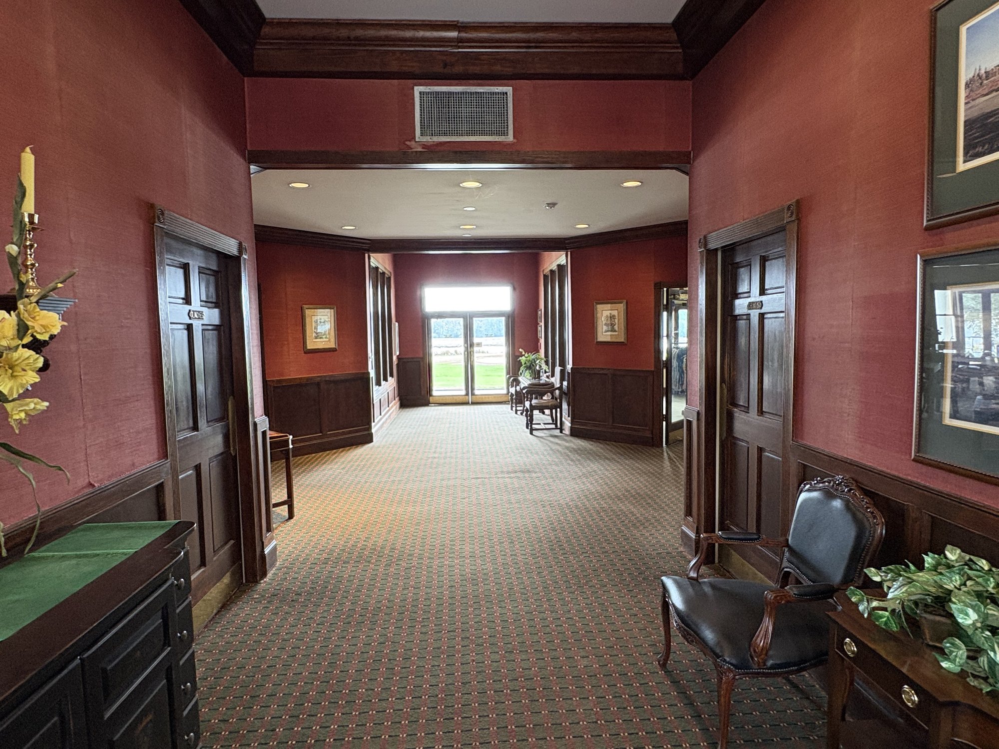 Glen Dornoch clubhouse interior hallway with burgundy walls and framed golf prints