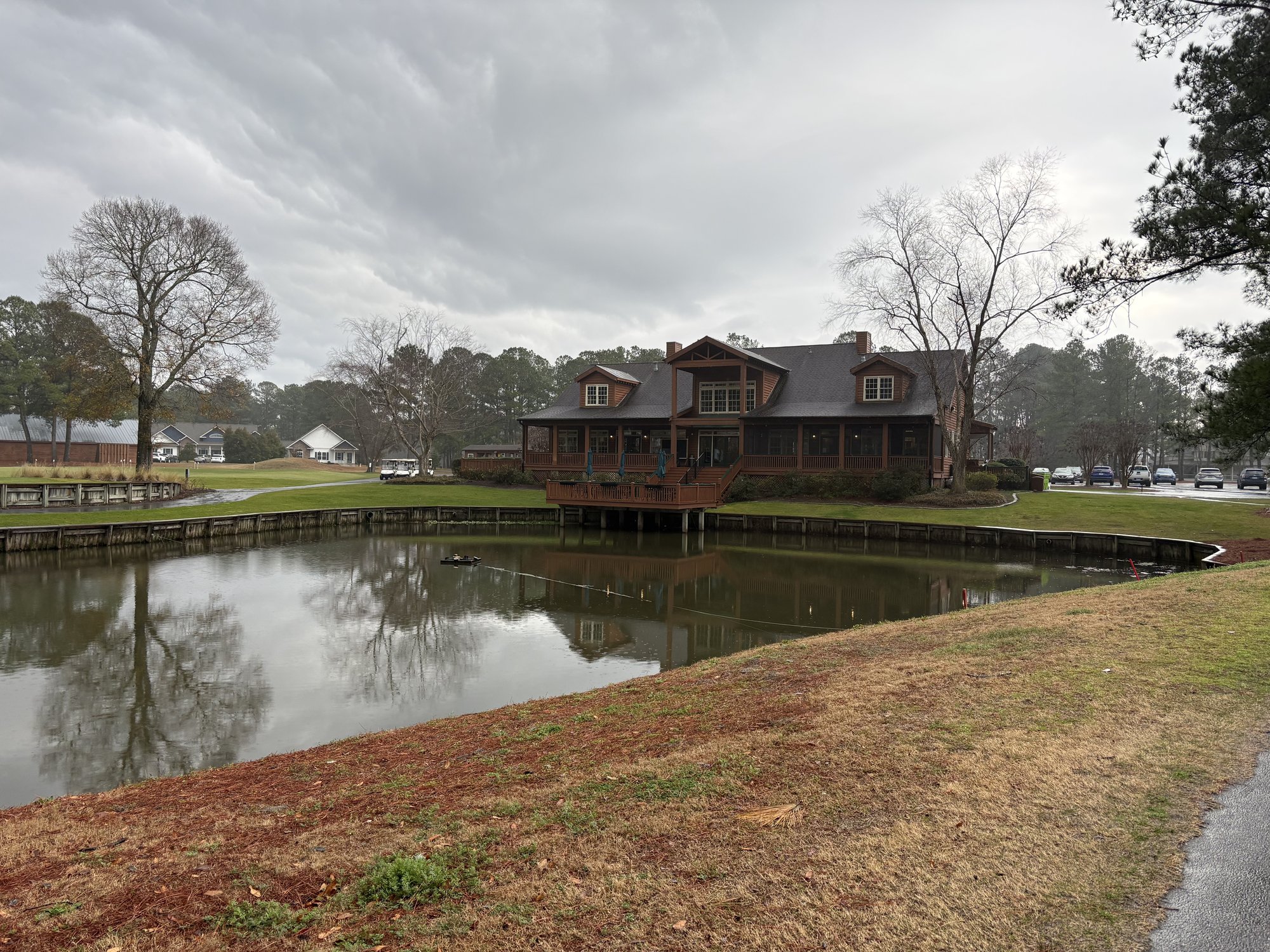 Meadowlands Golf Club lodge-style clubhouse reflected in pond Calabash NC