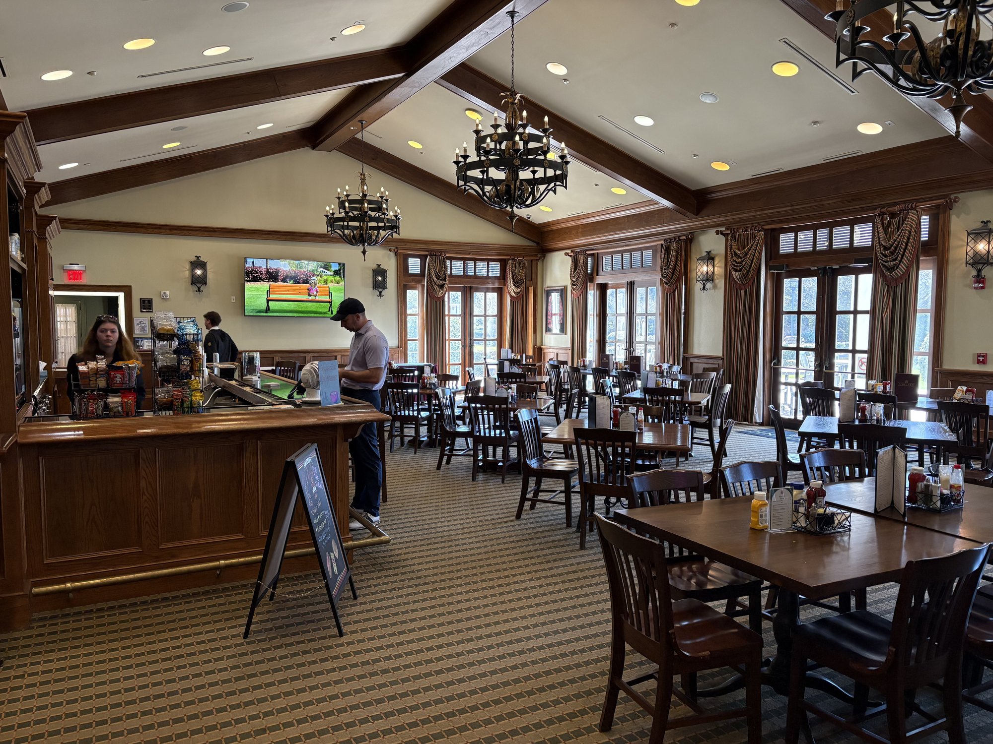 Pine Lakes Country Club clubhouse dining room with chandeliers and dark wood paneling