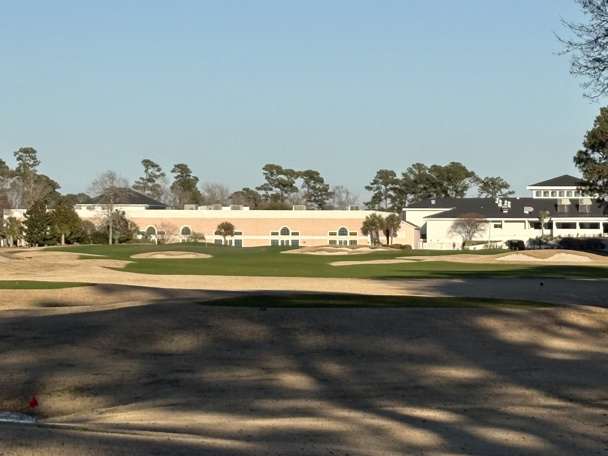 Approach to finishing hole with bunkers and clubhouse at Sea Trail Byrd Course Sunset Beach NC