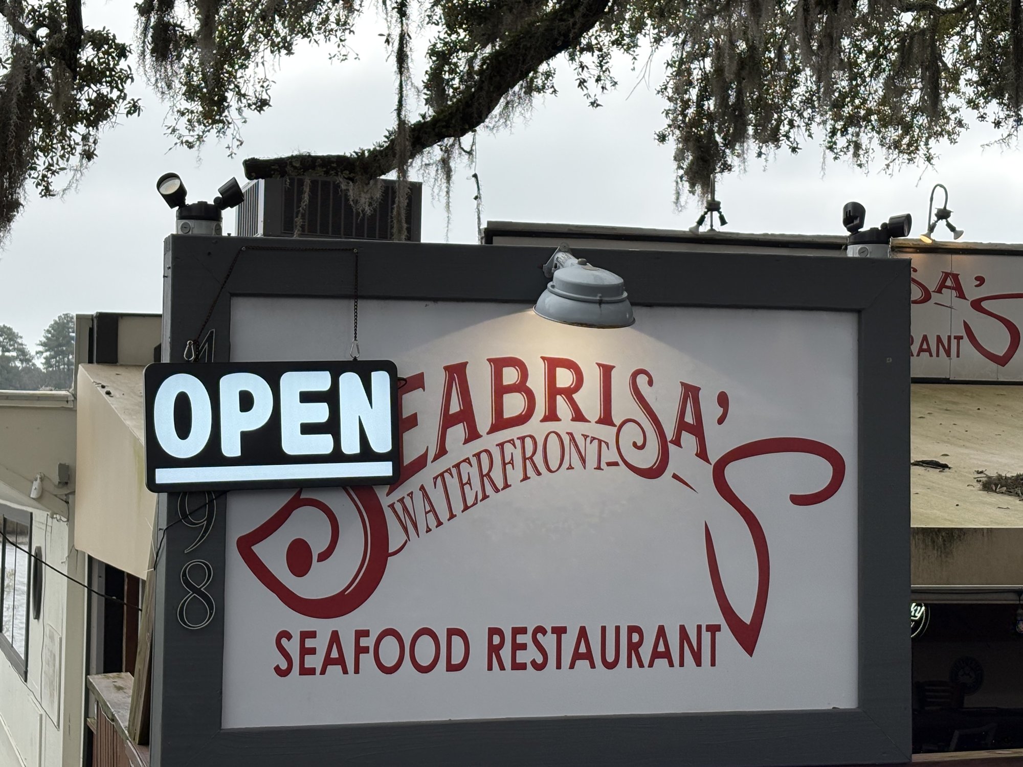Seabrisa's Waterfront Seafood Restaurant sign with Spanish moss in Little River SC
